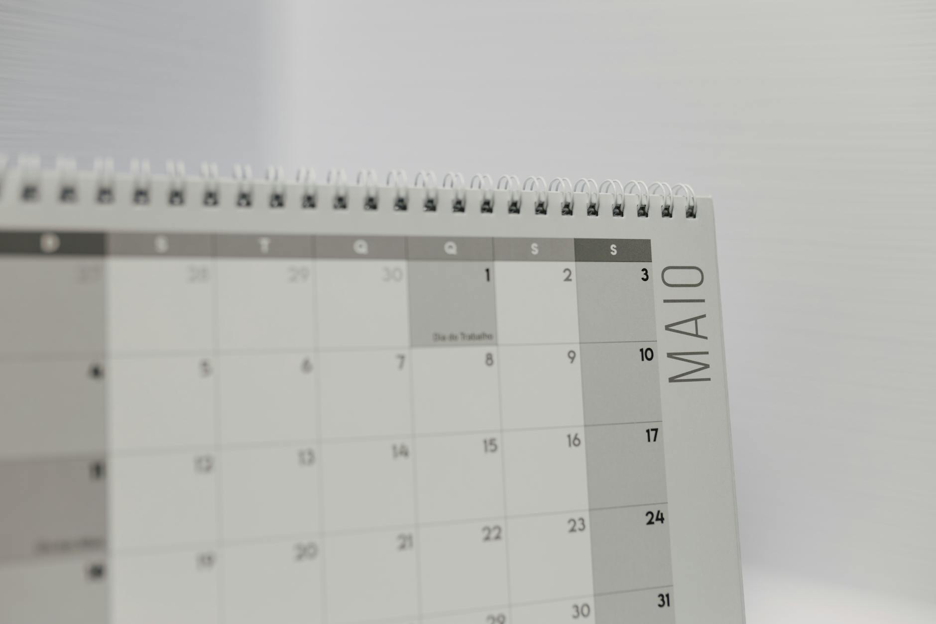 Calendrier à spirales indiquant le mois de mai avec un accent sur les jours de la semaine en portugais. — calendrier éditorial réseaux sociaux