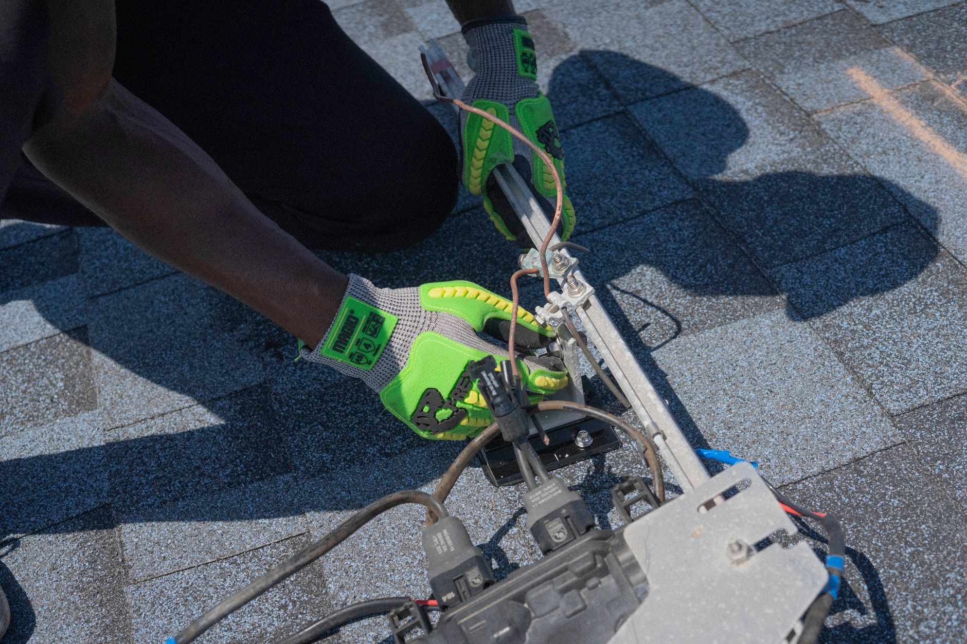 Gros plan d'un technicien travaillant sur l'installation de panneaux solaires avec des gants verts à Tampa, en Floride. — installer n8n